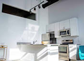Thumbnail 14 of 20 - A modern kitchen with a white countertop and stainless steel appliances.
