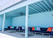 Thumbnail 21 of 22 - A blue couch with pillows under a white roof.