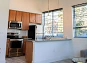 Thumbnail 7 of 22 - A modern kitchen with wooden cabinets and stainless steel appliances.