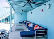 Thumbnail 24 of 24 - A blue couch with pillows and a fan on the ceiling.