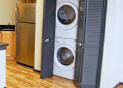 Thumbnail 3 of 7 - A washer and dryer are in a small laundry room.
