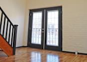Thumbnail 5 of 7 - A room with a staircase and a door with a window.