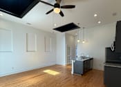 Thumbnail 2 of 8 - A room with wooden floors and a ceiling fan.