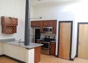 Thumbnail 3 of 6 - A kitchen with a stove top oven and a refrigerator.