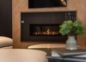 Thumbnail 31 of 39 - a fireplace with wood paneling and a vase of flowers on a coffee table at The Bend Arbordale, Virginia, 23188