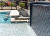 Thumbnail 21 of 39 - a swimming pool with a retaining wall and a water feature at The Bend Arbordale, Williamsburg