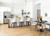 Thumbnail 3 of 33 - a kitchen and dining area with white cabinets and a table and chairs at Onyx at Westgate Apartments, Glendale, AZ