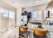 Thumbnail 2 of 34 - a kitchen and dining area with a glass door to a balcony at The Villas at Prairie Center, Brighton, CO, 80601