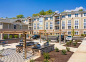 Thumbnail 39 of 39 - an outdoor patio with a firepit and picnic table at the enclave at woodbridge apartments in at The Bend Arbordale, Williamsburg