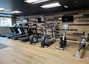 Thumbnail 39 of 50 - A gym with treadmills, exercise bikes, and elliptical machines.