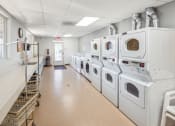 Thumbnail 12 of 15 - a laundromat with a row of washes and dryers in a room