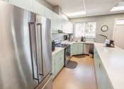 Thumbnail 11 of 15 - a kitchen with green cabinets and a stainless steel refrigerator