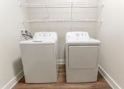 Thumbnail 15 of 37 - a washer and dryer in a room with a white wall and wood floor at Annandale Apartment Homes, Tennessee 37128