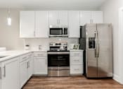 Thumbnail 2 of 37 - a white kitchen with stainless steel appliances and white cabinets at Annandale Apartment Homes, Murfreesboro, TN