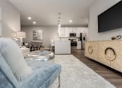 Thumbnail 7 of 37 - a living room with a couch and a chair and a kitchen at Annandale Apartment Homes, Tennessee