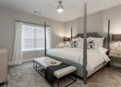 Thumbnail 10 of 37 - a bedroom with a bed and a table in front of a window at Annandale Apartment Homes, Murfreesboro, 37128