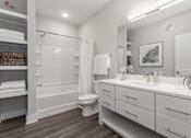 Thumbnail 13 of 37 - a bathroom with a large mirror and a toilet and a shower at Annandale Apartment Homes, Murfreesboro