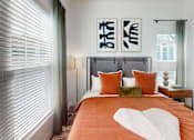Thumbnail 6 of 48 - A bedroom with a bed, pillows, and two framed artworks on the wall.