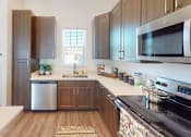 Thumbnail 1 of 48 - A modern kitchen with dark wood cabinets and stainless steel appliances.