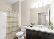 Thumbnail 25 of 44 - a bathroom with a white toilet next to a bathtub with a shower curtain