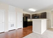 Thumbnail 23 of 44 - a kitchen with dark cabinets and a white island with a black refrigerator