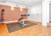 Thumbnail 25 of 43 - gym area with a weight machine and mirror at 10 West Apartments, Long Beach, New York