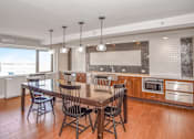 Thumbnail 18 of 43 - a club house with a table and chairs and a kitchen at 10 West Apartments, New York 11561