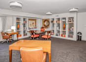 Thumbnail 17 of 43 - a club house with tables and chairs and bookshelves at 10 West Apartments, Long Beach, 11561