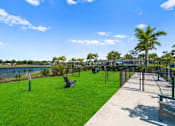 Thumbnail 39 of 46 - a dog park with a chain link fence and benches on the grass at Artesia at Lakewood Ranch Apartments, Bradenton, 34211