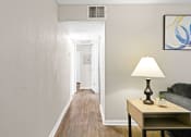 Thumbnail 11 of 29 - a living room with a lamp and a couch and a hallway with a door to at Diamond  Trail Apartments, Oklahoma City, 73112