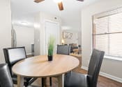 Thumbnail 5 of 29 - a dining room with a wooden table and black leather chairs at Diamond  Trail Apartments, Oklahoma
