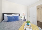 Thumbnail 9 of 24 - bedroom with yellow blanket on bed and blue pillows and blue paintingbedroom with yellow blanket on bed and blue pillows with view looking into bathroom
