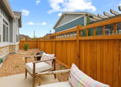 Thumbnail 19 of 34 - a backyard with a wooden fence and patio furniture at The Villas at Prairie Center, Brighton, 80601