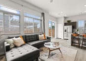 Thumbnail 4 of 34 - a living room with a couch coffee table and a kitchen in the background at The Villas at Prairie Center, Colorado