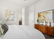 Thumbnail 9 of 34 - a bedroom with a large white bed and a wooden dresser at The Villas at Prairie Center, Colorado