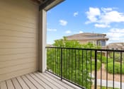 Thumbnail 27 of 44 - a balcony with a view of the yard and houses in the background