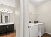 Thumbnail 24 of 44 - a bathroom with a washer and dryer and a sink