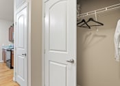 Thumbnail 20 of 44 - a walk in closet with a white door and a hanger on the wall
