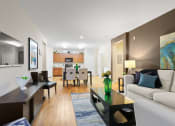 Thumbnail 7 of 44 - a living room with a couch coffee table and a dining room table in the background