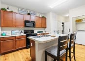 Thumbnail 3 of 44 - a kitchen with wooden cabinets and a white counter top with three black chairs