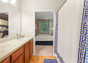 Thumbnail 16 of 44 - a bathroom with a shower and a bed in the background