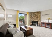 Thumbnail 2 of 40 - the living room has a large stone fireplace and a couch at Silver Reef Apartments, Lakewood, 80228
