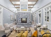 Thumbnail 11 of 30 - a living room filled with furniture and a large stone fireplace at Cirrus Apartments, Ashland, MA