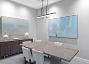 Thumbnail 17 of 30 - a dining room with a wooden table and white chairs and two paintings on the wall at Cirrus Apartments, Massachusetts