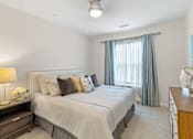 Thumbnail 7 of 30 - a bedroom with a bed and a dresser with a lamp at Cirrus Apartments, Ashland, Massachusetts