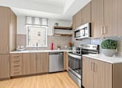 Thumbnail 3 of 39 - a kitchen with wooden cabinets and white countertops at 8000 Uptown Apartments, Broomfield