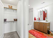 Thumbnail 18 of 39 - a bathroom with white walls and a red rug at 8000 Uptown Apartments, Broomfield, CO