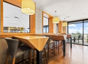 Thumbnail 15 of 35 - a dining area with wooden tables and chairs and a large window with a view of the outdoors