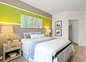 Thumbnail 16 of 48 - a bedroom with a large bed and a bathroom in the background