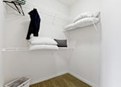 Thumbnail 19 of 48 - a room with a white wall and a white shelf with white pillows and a black jacket